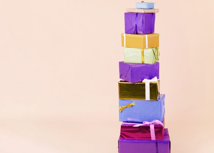 stack-colorful-wrapped-gift-boxes-beige-background