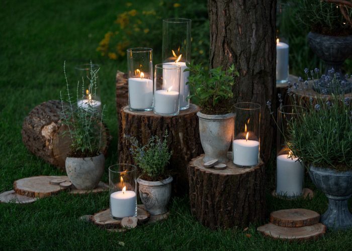 Tall vases with white candles stand on the blocks in the garden